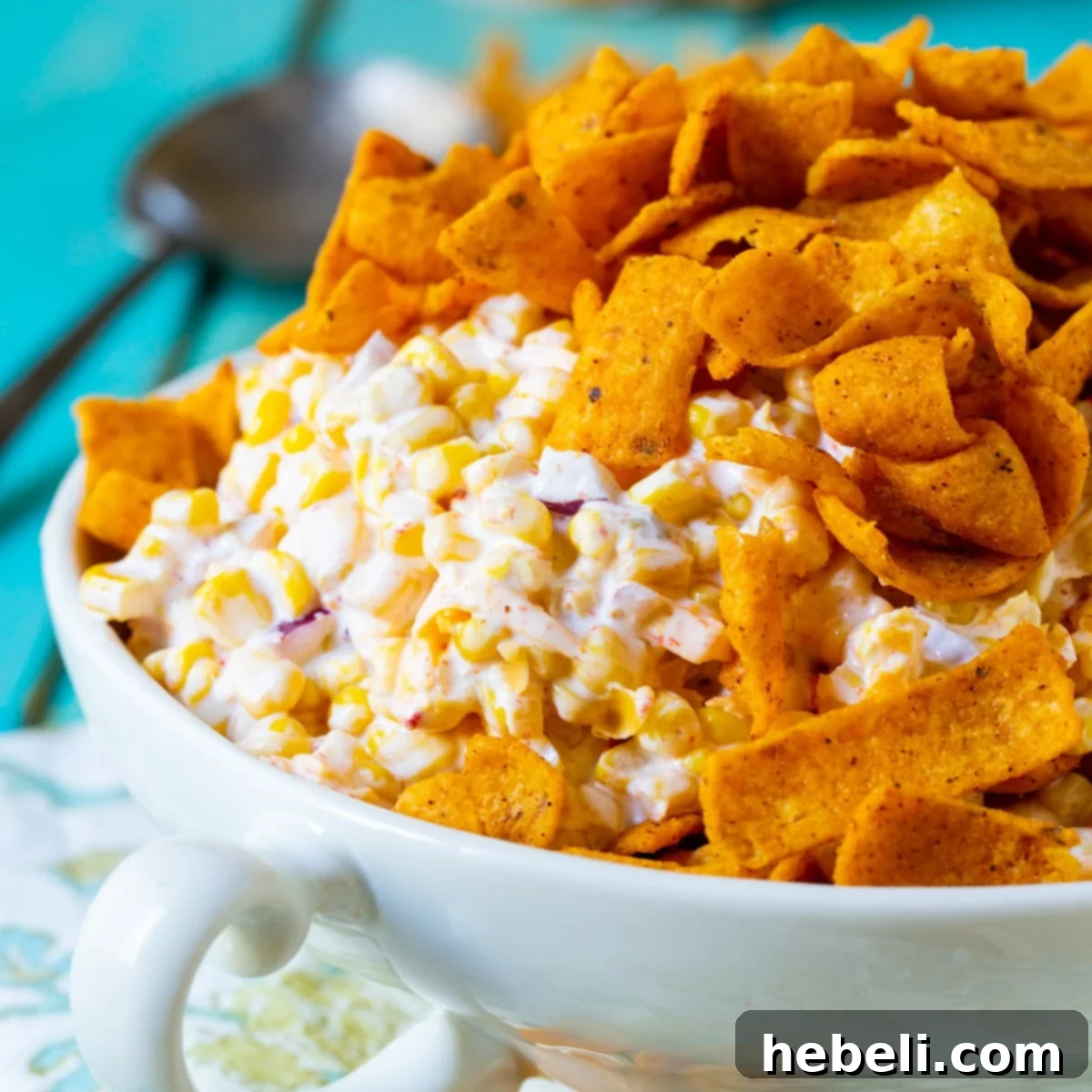 Frito Corn Salad topped with frito chips in a serving bowl.