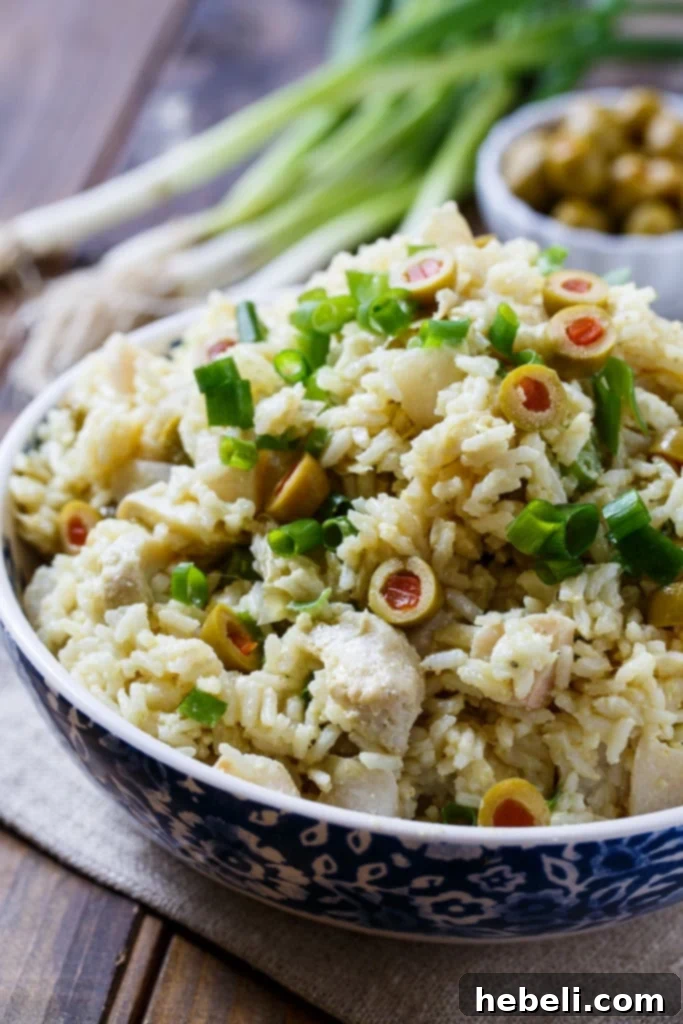Mediterranean Artichoke Rice Salad 4 Artichoke-Rice Salad with a serving spoon, showcasing its creamy texture and fresh ingredients.