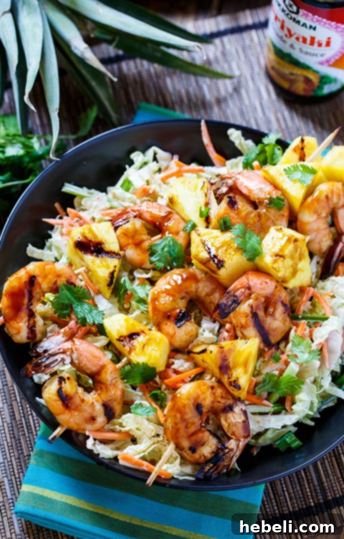 Close-up of grilled teriyaki shrimp skewers with pineapple on a platter