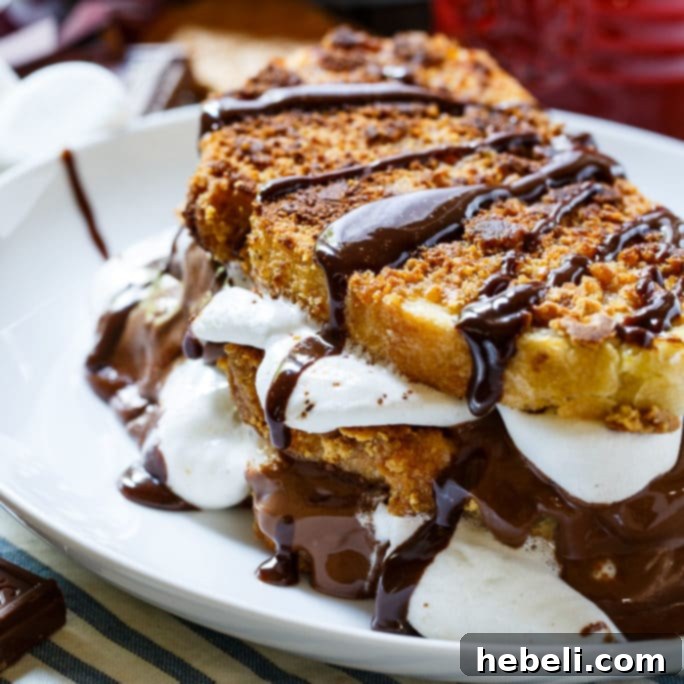 Delicious S'mores French Toast stacked high, drizzled with syrup and sprinkled with graham cracker crumbs