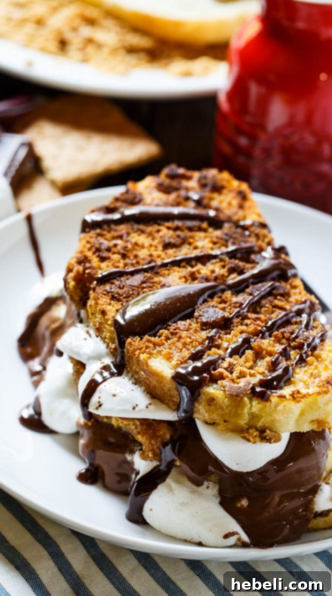 Close-up of S'mores French Toast coated in crushed graham crackers, revealing melted marshmallows and chocolate inside