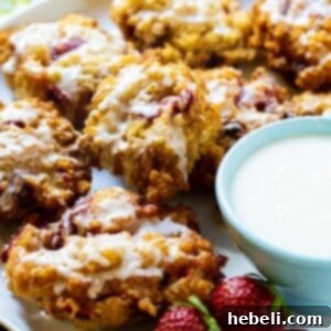 Glazed Strawberry Fritters on a plate with bowl of glaze.