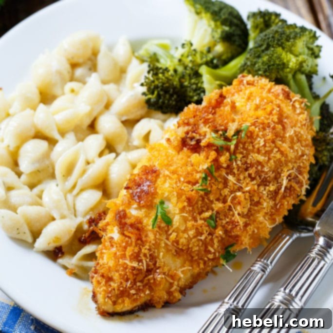 Perfectly golden and crispy Baked Parmesan Chicken served on a plate with garnishes