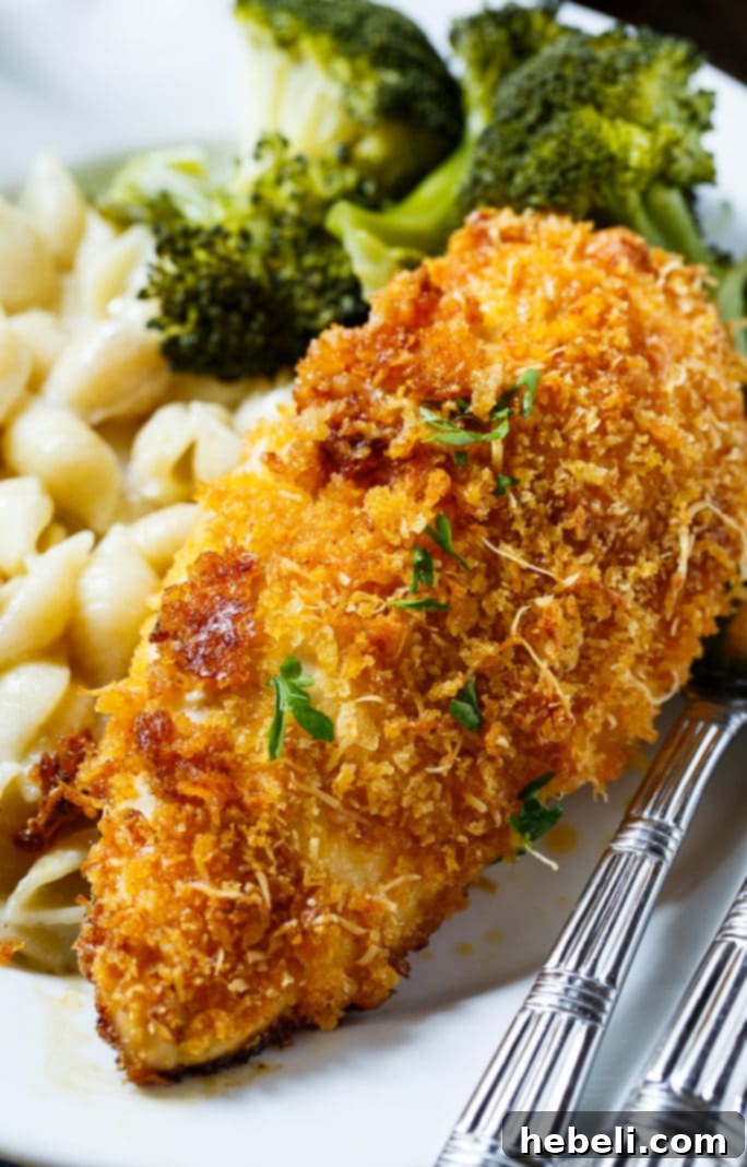 Delicious baked Parmesan chicken, golden brown and garnished with fresh herbs, presented as a finished dish