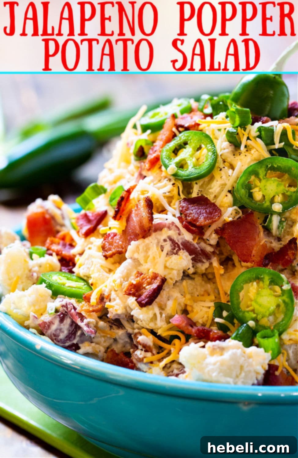A large, vibrant serving bowl filled with creamy Jalapeno Popper Potato Salad, garnished with crispy bacon and fresh jalapeno slices, ready to be served at a gathering.