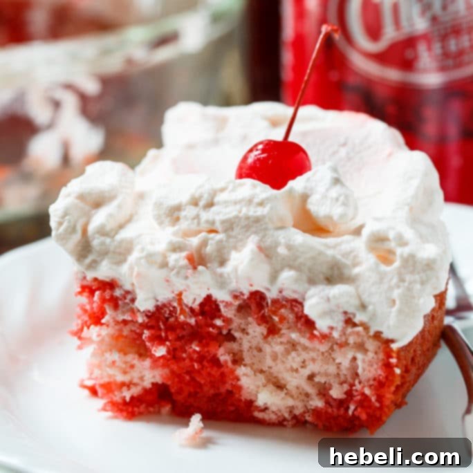 Sparkling Cherry Poke Cake 2 Delicious Cheerwine Poke Cake with whipped cream and cherry garnish, ready to serve at a summer picnic.