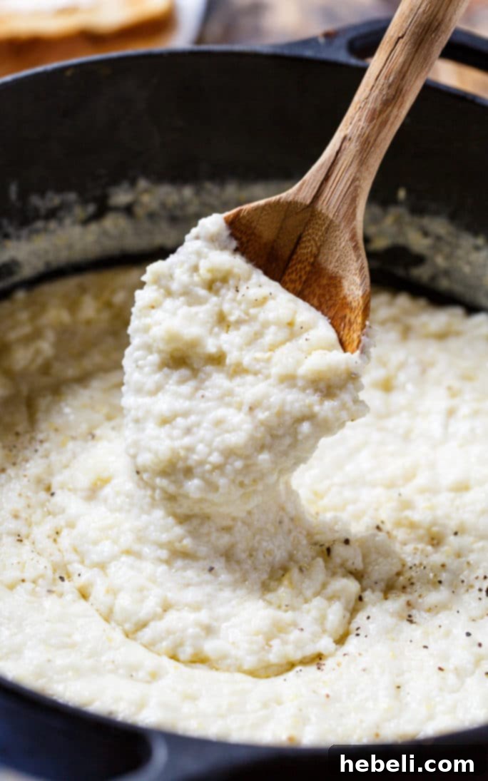 A serving of creamy grits topped with a pat of butter, showcasing its smooth, rich texture and inviting golden hue.