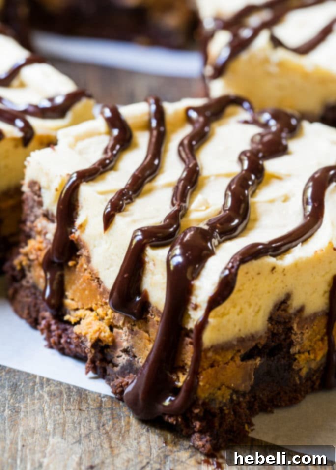 Close-up of a slice of Peanut Butter Cup Brownie showing the layers of fudgy brownie, melted peanut butter cups, and smooth frosting