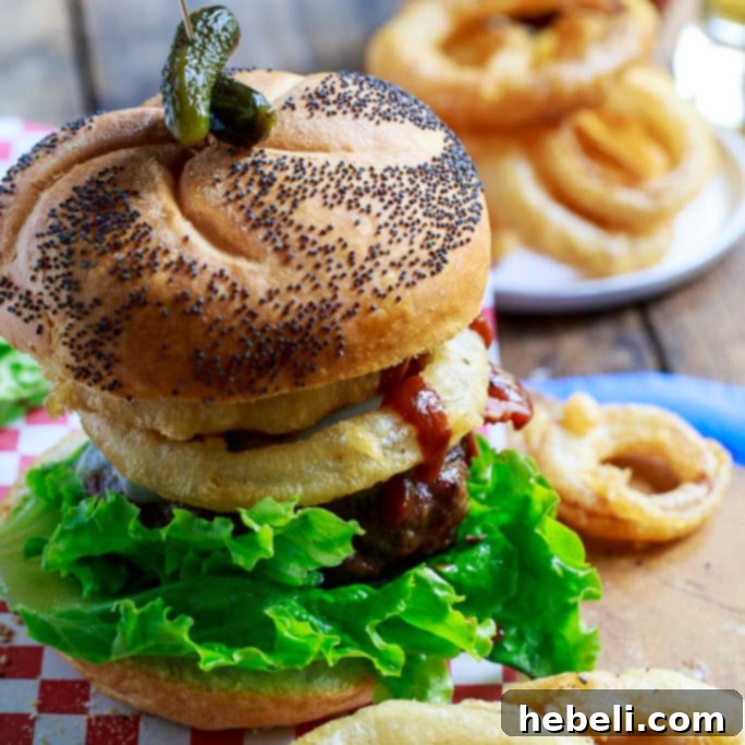 Juicy Cowboy Burgers topped with crispy bacon, golden onion rings, and rich Stubb's BBQ sauce on a toasted bun.