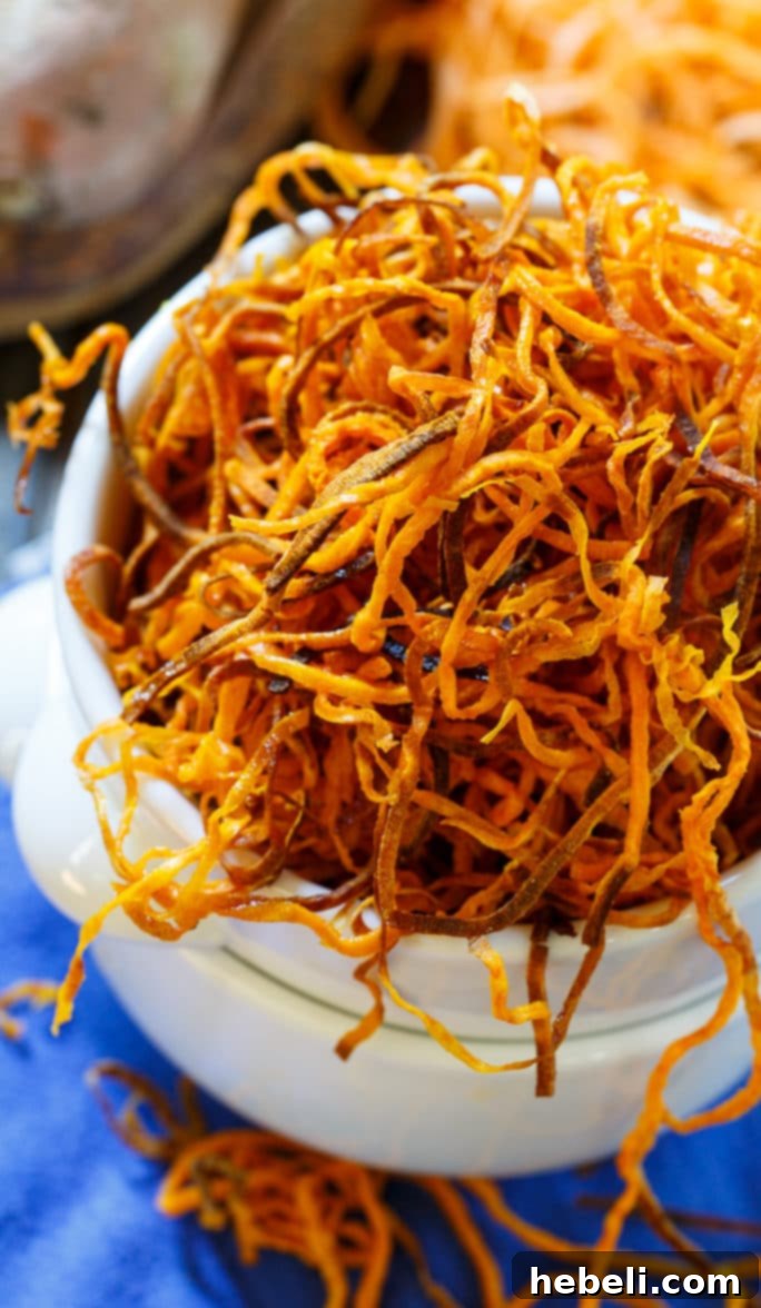 A bowl overflowing with golden-brown, crispy sweet potato straws