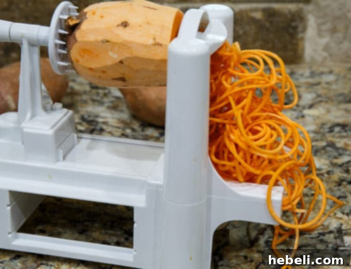 Close-up of a spiralizer creating thin shoestring sweet potato fries