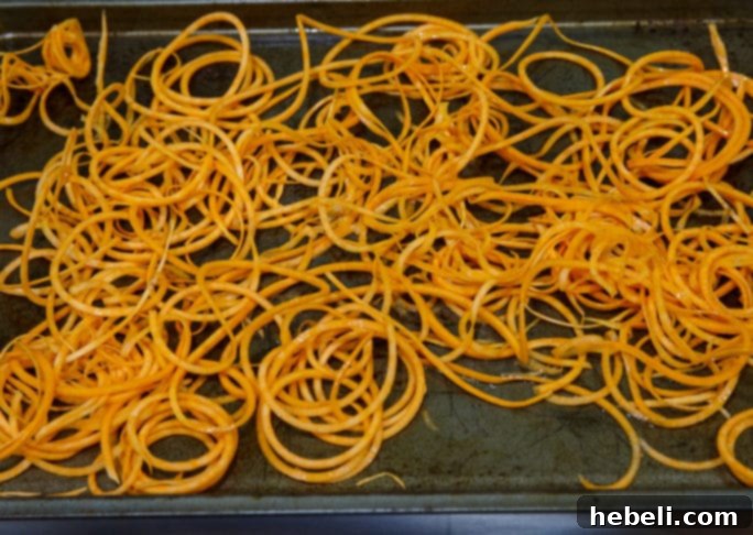 Baked sweet potato straws tossed with olive oil and salt, ready for the oven