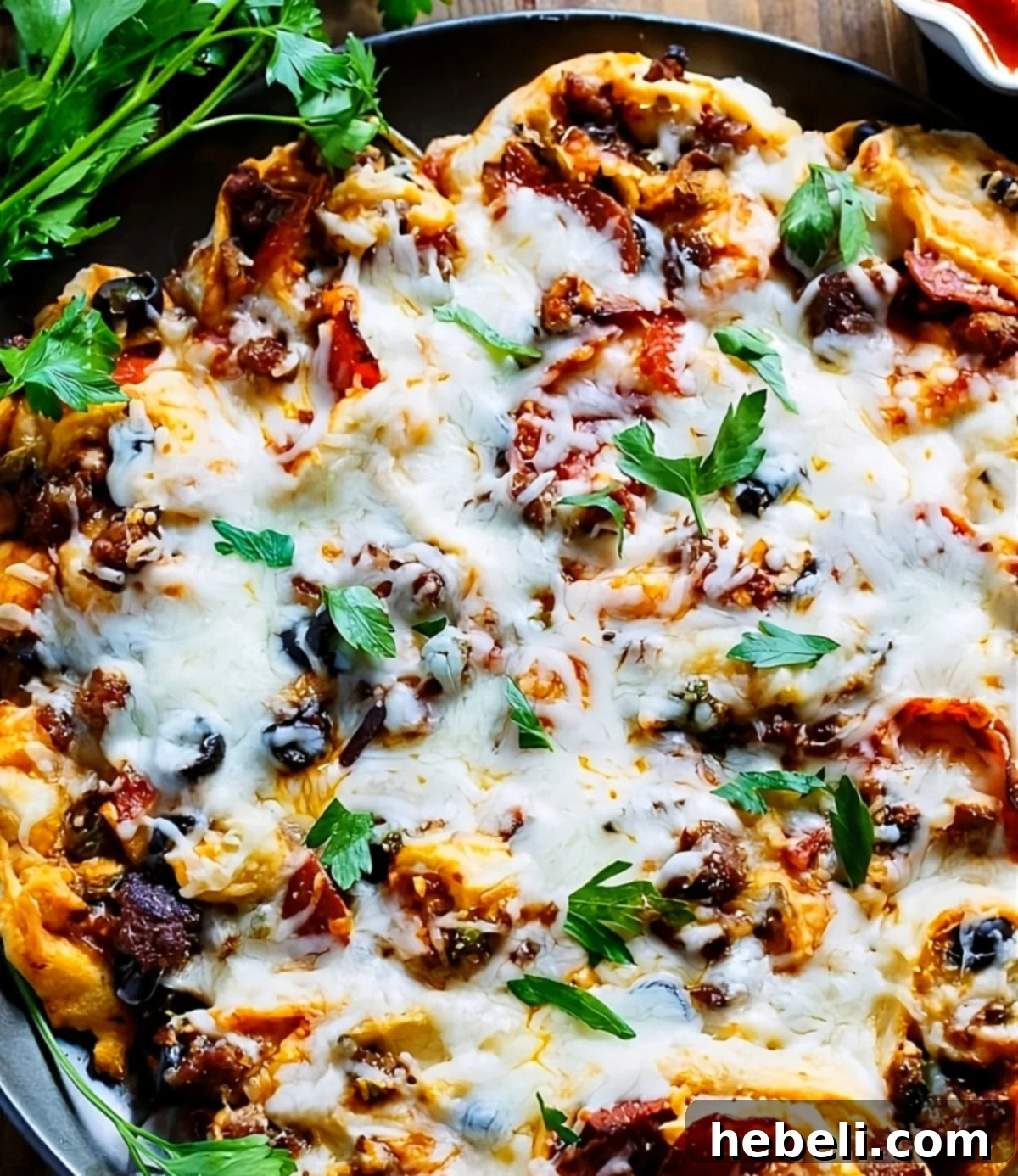 Delicious Pull-Apart Supreme Pizza Pinwheels arranged on a pizza pan, ready to be enjoyed.