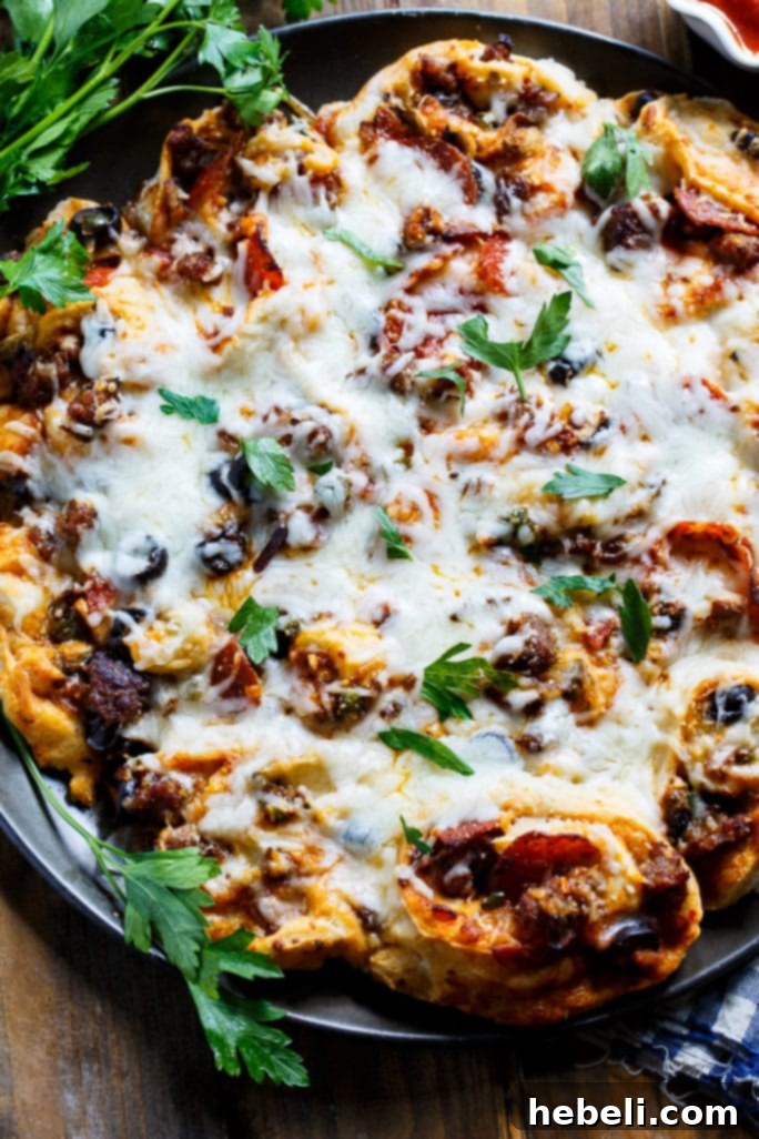 Close-up of golden Pull-Apart Supreme Pizza Pinwheels with melted cheese from Melissa's Southern Cookbook.