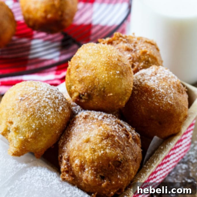 Delicious Deep-Fried Cookie Dough balls dusted with powdered sugar, served on a white plate