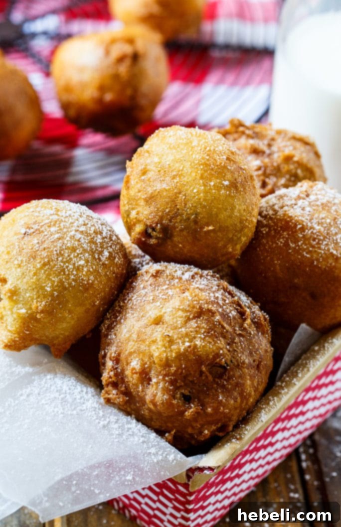 A beautifully arranged plate of freshly Deep-Fried Cookie Dough balls, garnished with a generous sprinkle of powdered sugar