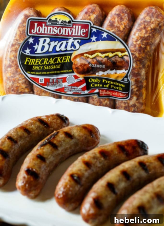 Assembled Brats in a Blanket before baking, showing the bratwurst, cheese, mustard, and sauerkraut neatly wrapped in puff pastry on a baking sheet.