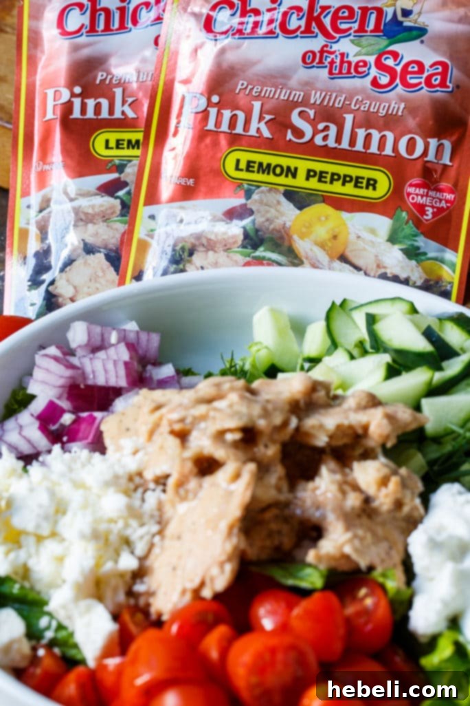 Hand holding a Greek Salmon Pita Sandwich