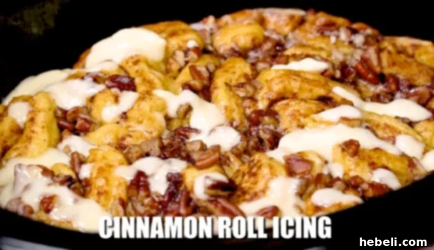 Final layer of icing drizzled over the hot, finished cinnamon roll casserole.