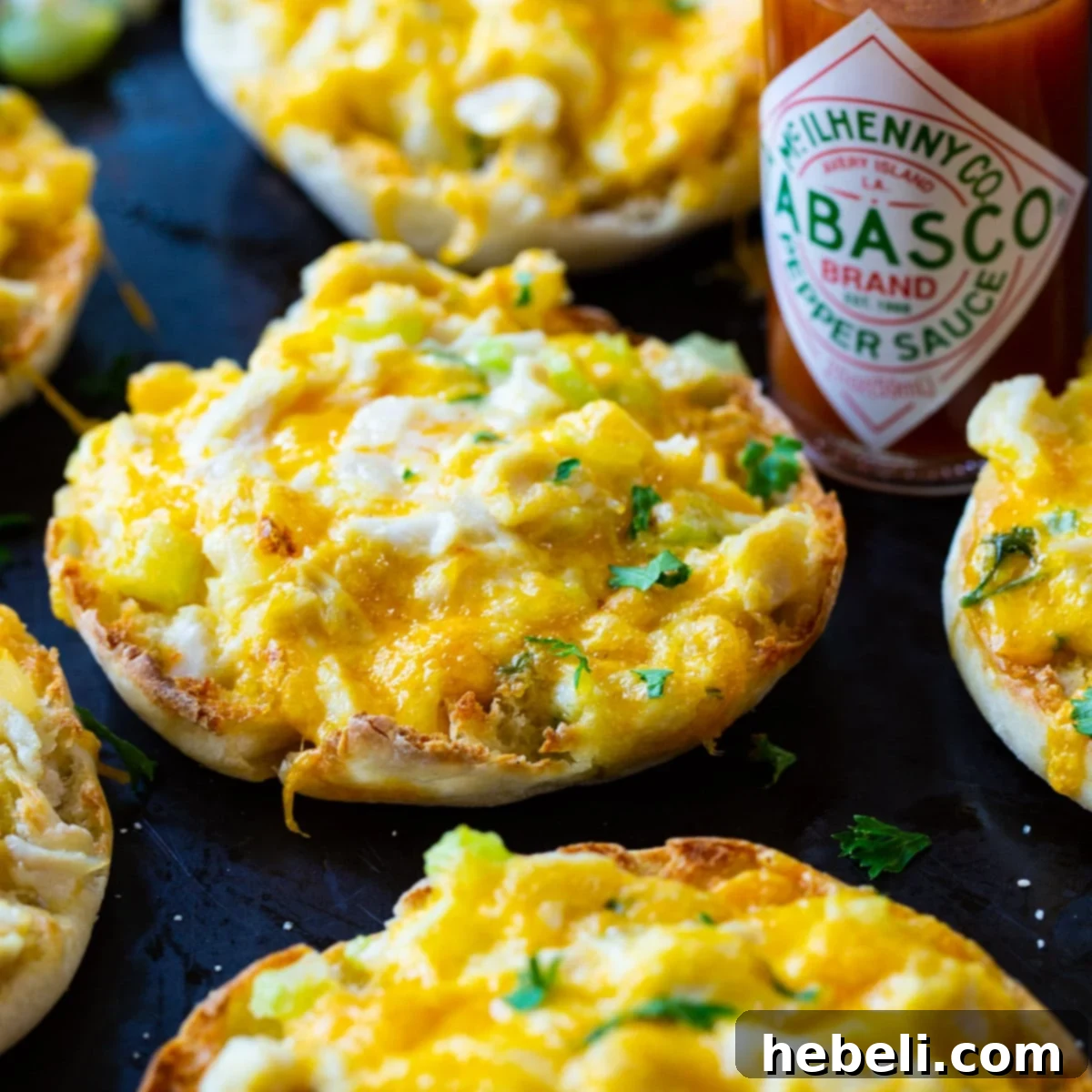 Sensational Crab Melts 2 Golden brown Crab Melts fresh from the oven, served on a baking sheet, showcasing beautifully melted cheese and a delicious crab mixture.