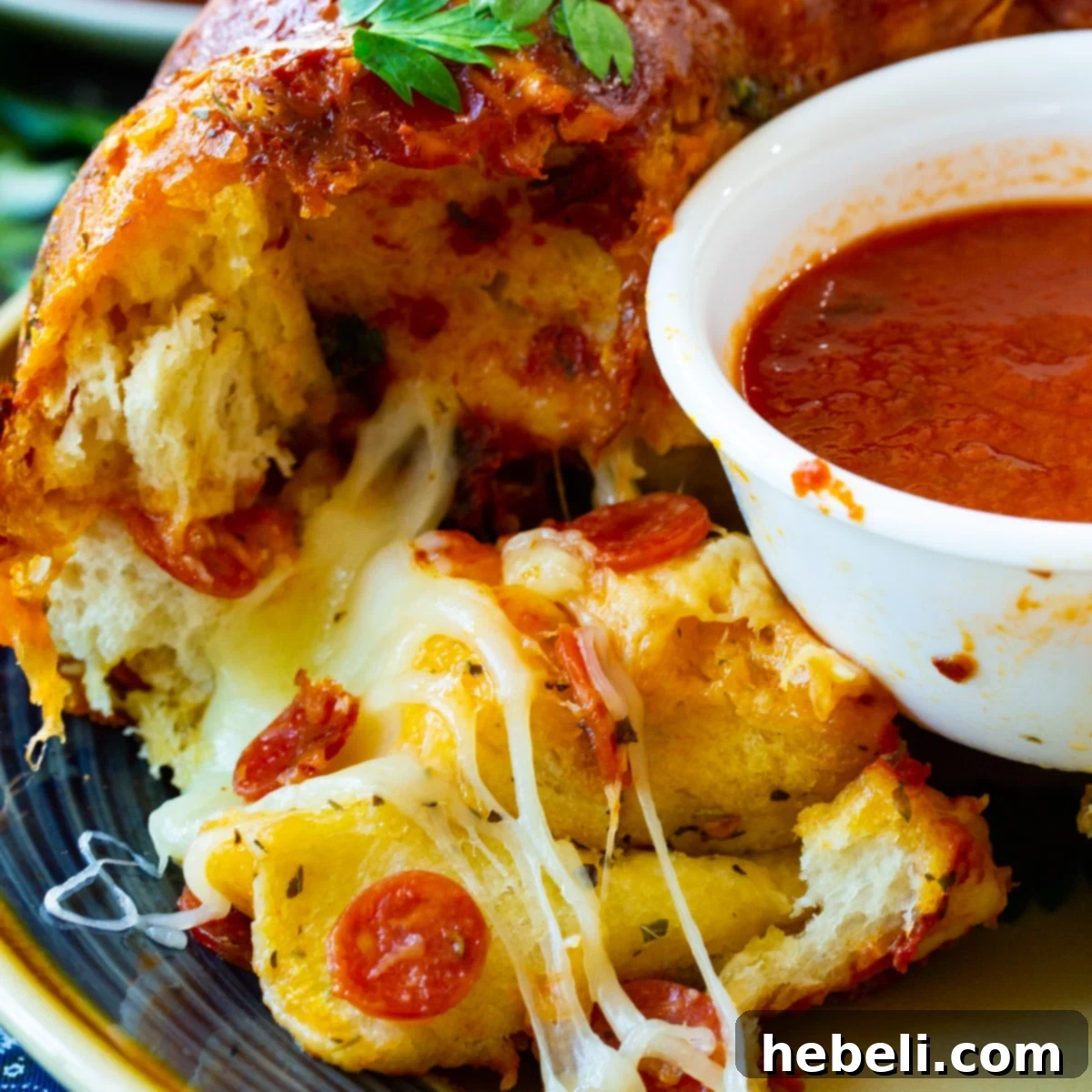 Delicious Pizza Monkey Bread on a plate, with a small bowl of marinara sauce for dipping.