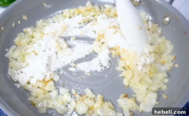 Kickin' Jalapeno Popper Chicken Bake 4 Sprinkling flour over the cooked onions and butter to create a roux for the sauce.