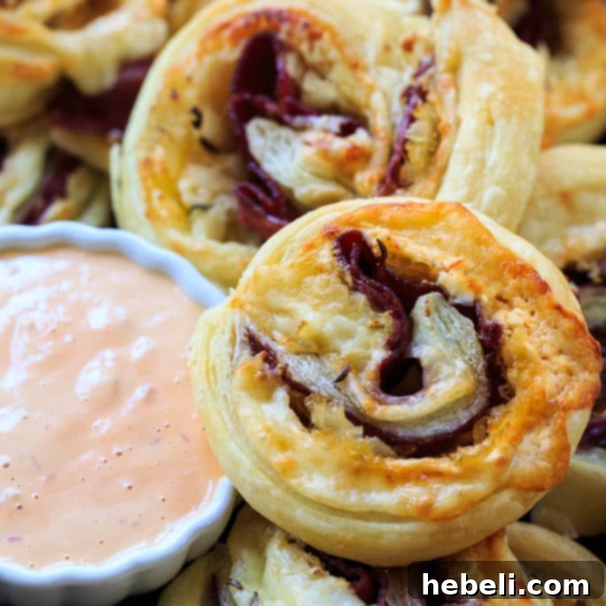 Golden brown Reuben Pinwheels arranged on a serving platter, showcasing their vibrant layers.