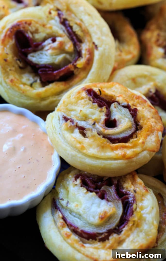 Close-up of baked Reuben Pinwheels, showcasing the golden puff pastry and vibrant filling.