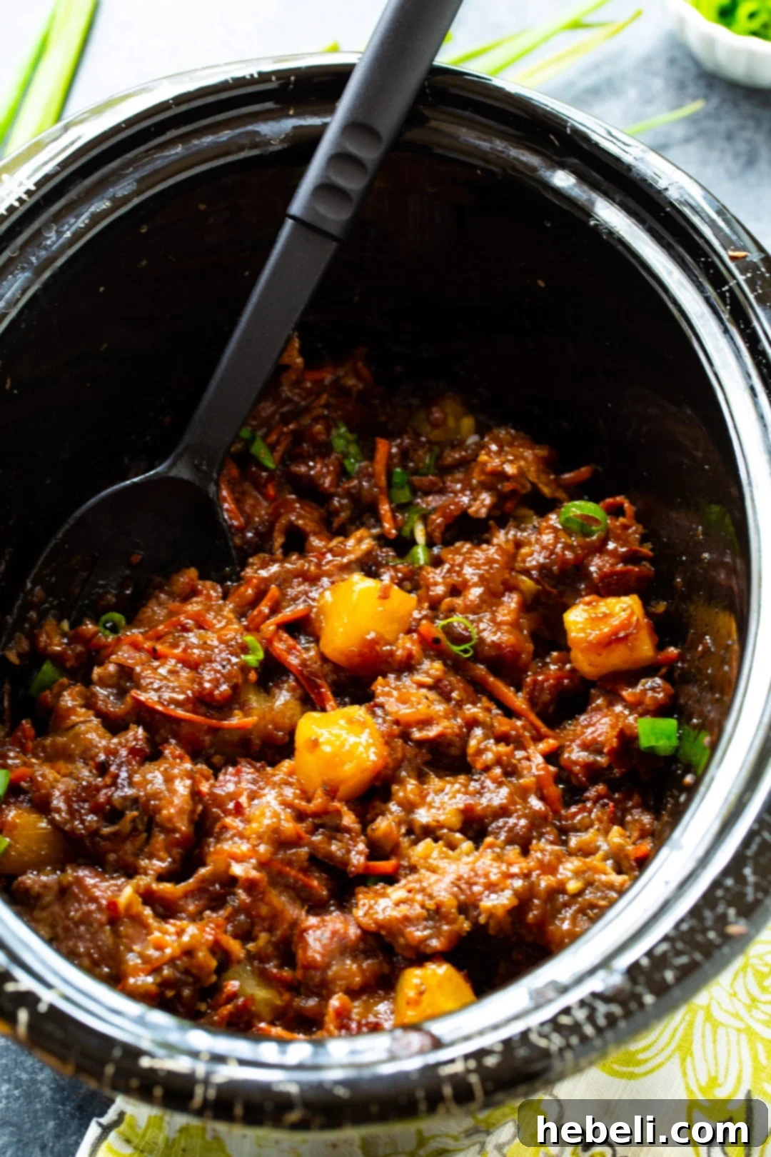 Spicy Mongolian Beef and Pineapple simmering gently in a slow cooker, showcasing the rich, thick sauce.