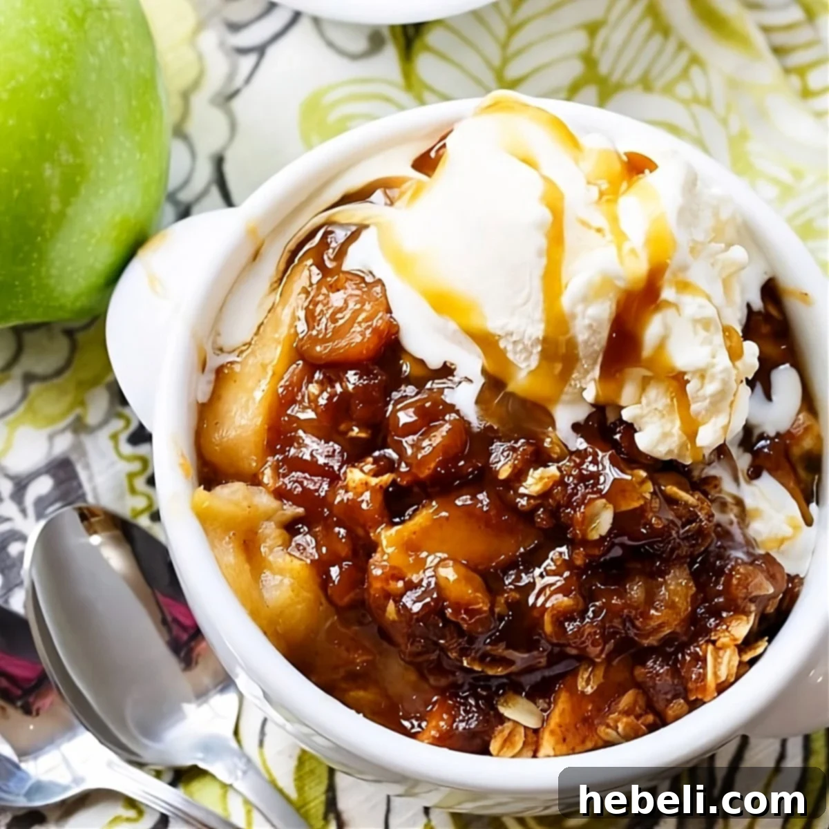 Golden Butterscotch Slow Cooker Apple Crisp 2 Butterscotch Apple Crisp topped with vanilla ice cream in a white bowl, ready to be enjoyed.