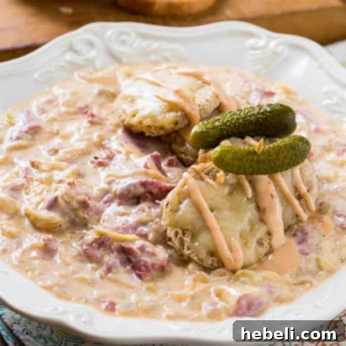 Delicious Reuben Soup, a hearty comfort food meal, served in a bowl with melted Swiss cheese and fresh garnishes.