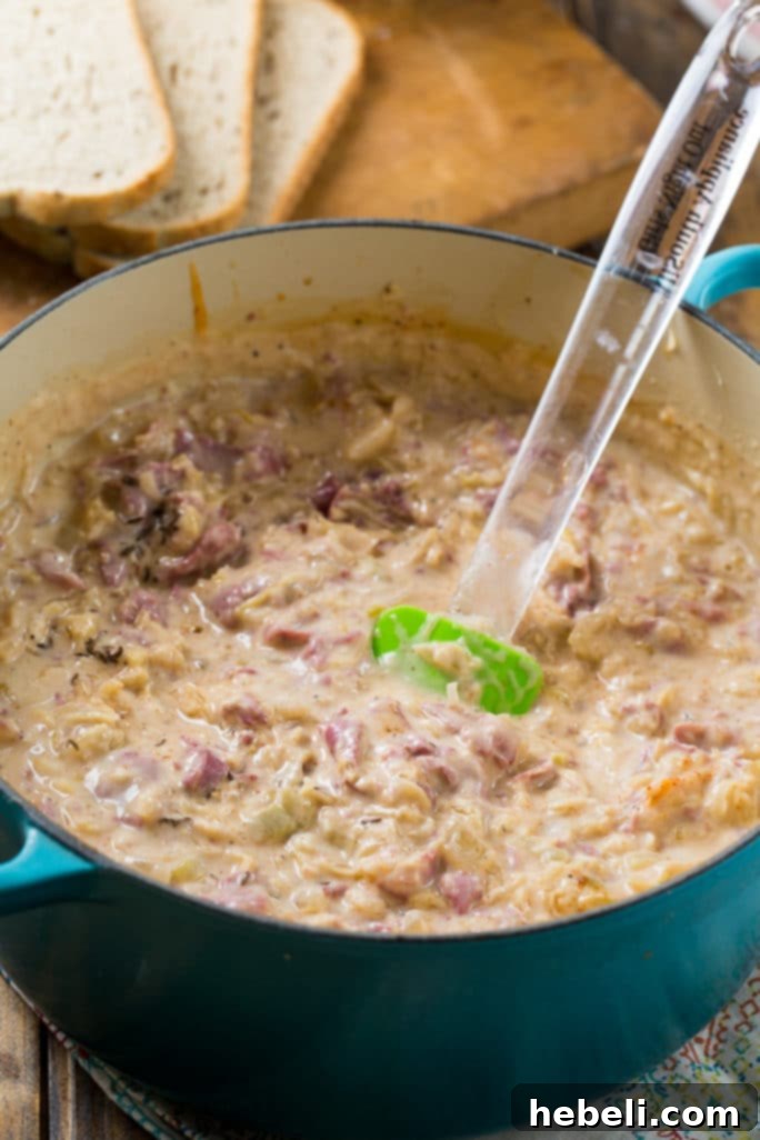 Close-up of Reuben Soup featuring generous chunks of corned beef and melted Swiss cheese, highlighting its rich texture.
