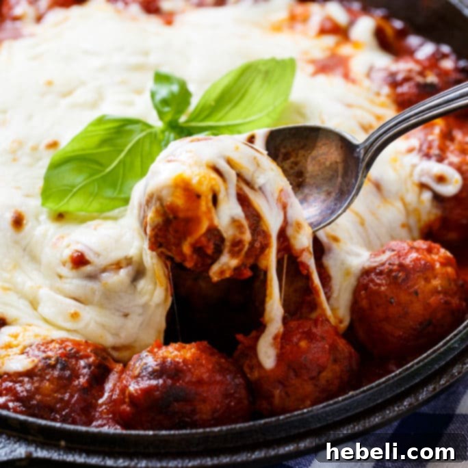 Delicious Cheesy Meatball Skillet, perfect for dinner or an appetizer, with melted cheese and fresh basil.