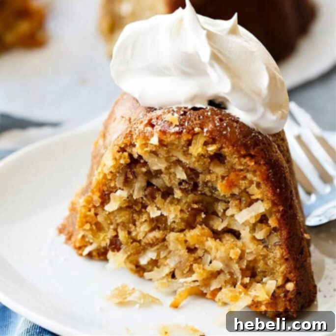 A delectable slice of Vanilla Wafer Cake, generously topped with fluffy whipped cream, showcasing its moist texture and rich golden hue.