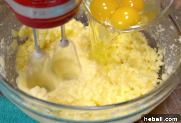 Mixing in eggs, showing the batter gradually coming together smoothly.