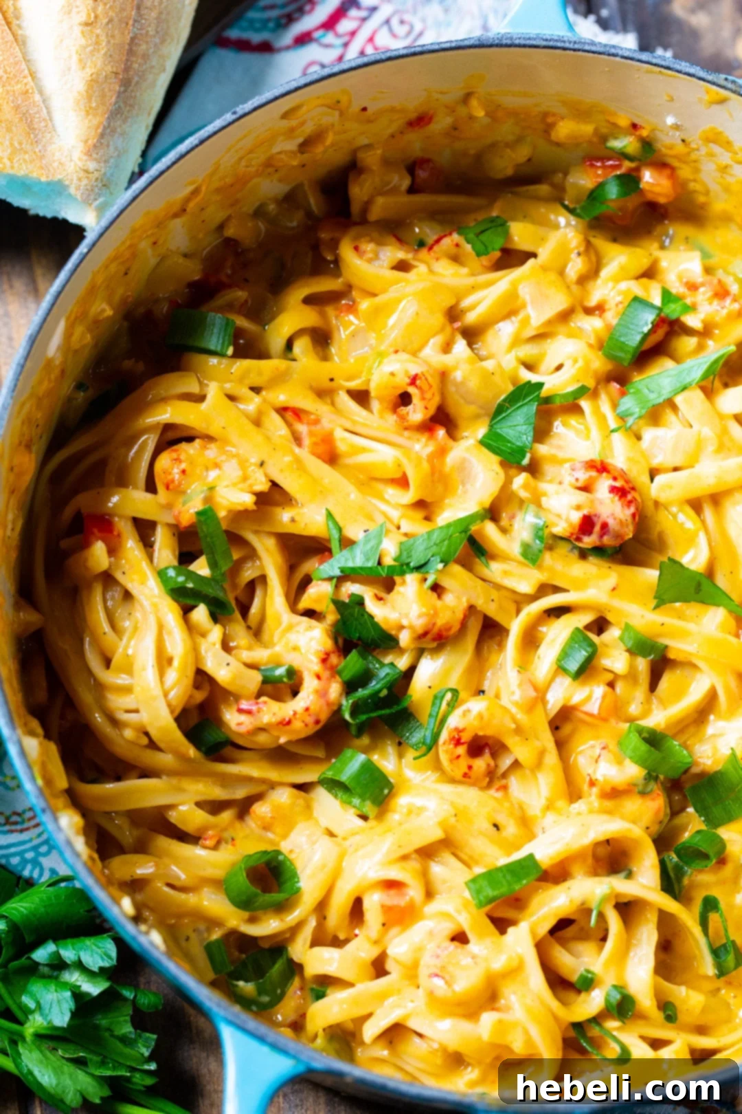 A close-up of creamy crawfish fettuccine in a Dutch oven, highlighting its rich texture.