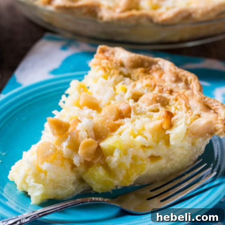A beautifully baked Pineapple Coconut Macadamia Pie, golden brown and garnished with coconut flakes.