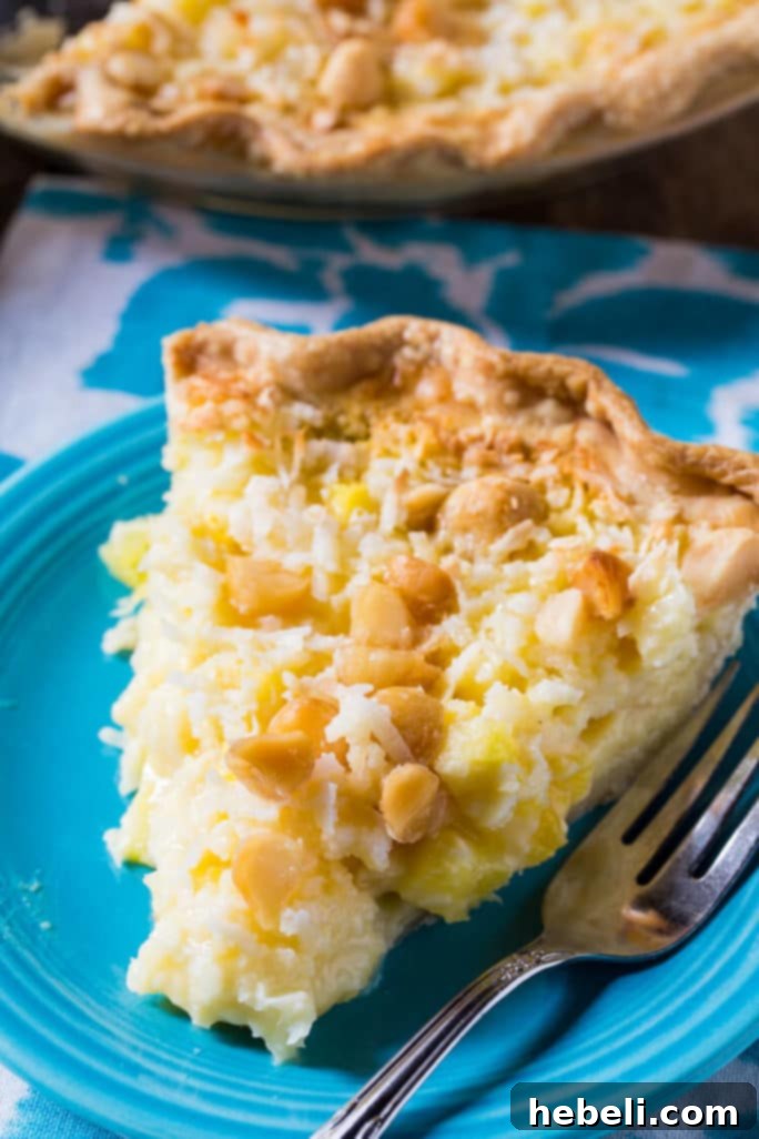 A whole Pineapple Coconut Macadamia Pie, beautifully baked with a golden crust and tropical topping, ready to be sliced.