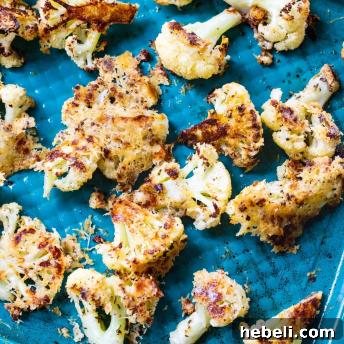 Crispy Parmesan Roasted Cauliflower florets on a baking sheet, ready to serve.