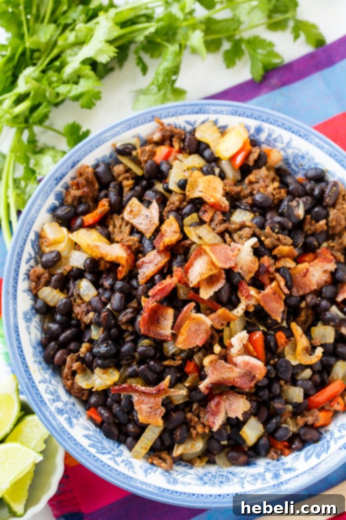 Close-up view of Chorizo Black Beans, showcasing the delicious texture and rich color, with visible pieces of chorizo and bacon.