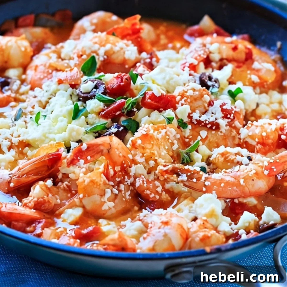 Mediterranean Feta Tomato Shrimp 2 A close-up of Greek Shrimp with Tomatoes and Feta sizzling in a cast-iron skillet, garnished with fresh herbs.