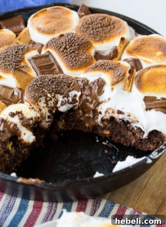Serving a slice of warm S'mores Skillet Brownie from the pan