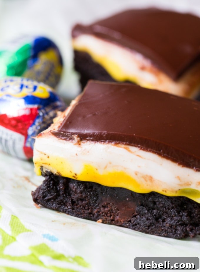 Decadent Cadbury Egg Brownies 4 A plate of Cadbury Egg Brownies, one piece bitten to show layers