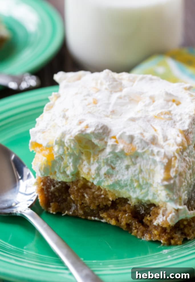 A close-up shot of Pineapple Delight with its thick graham cracker crust, creamy center, and fluffy pineapple topping.