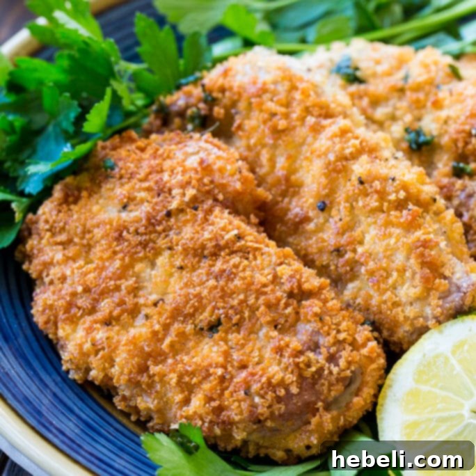 Crispy Pork Milanese 2 Perfectly pan-fried Pork Milanese cutlets on a plate