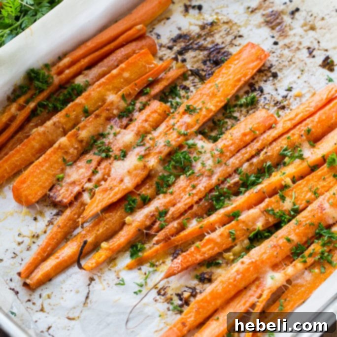 Parmesan Roasted Carrots beautifully arranged on a white plate with fresh herbs
