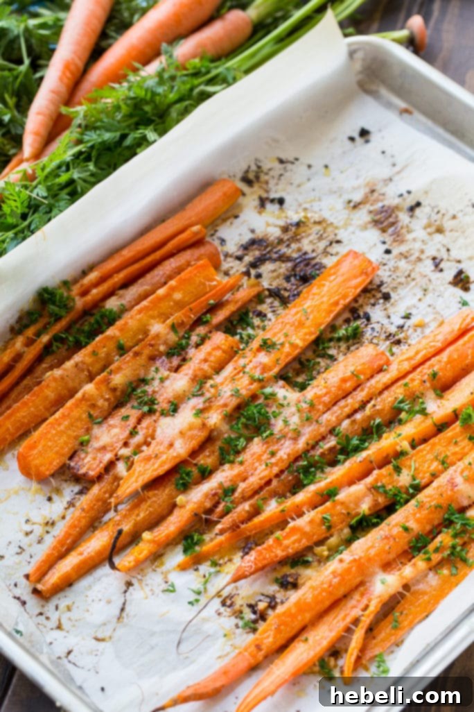 Close-up of vibrant, fresh carrots with green tops, indicating freshness