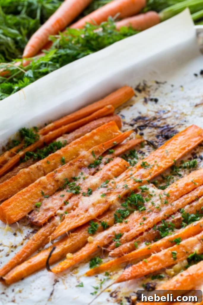 Carrots tossed with butter, garlic, and pepper, spread on a baking sheet lined with parchment paper