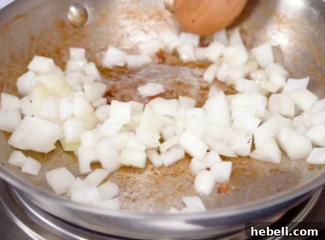 Chopped onions sautéing in a skillet with bacon grease until soft and translucent.