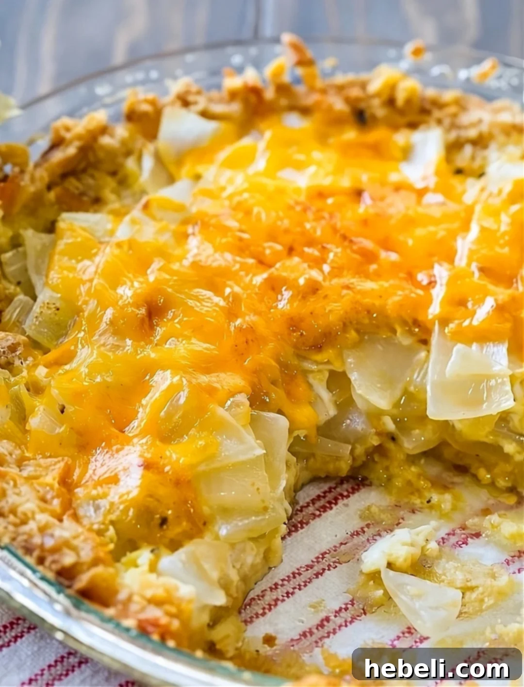 A whole Vidalia Onion Pie, showcasing its golden Ritz Cracker Crust and perfectly baked filling, with a slice already removed.